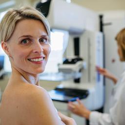 Frau lächelt bei Brustkrebs-Vorsorge-Untersuchung