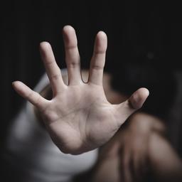 Eine Frau hält ihre Hand schützend vor sich