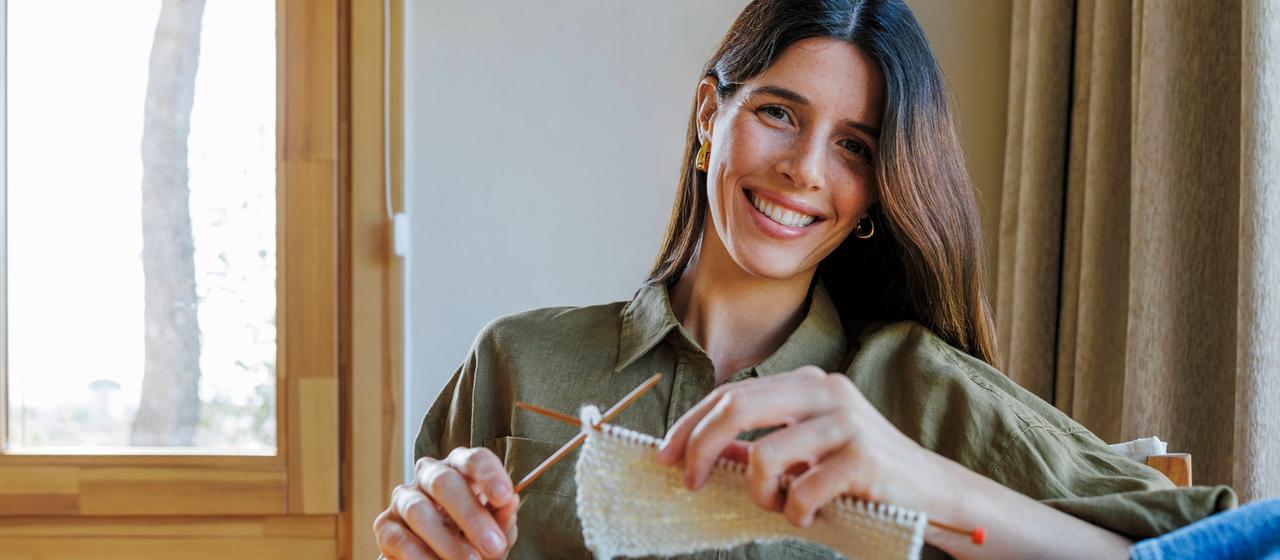 Lächelnde Frau beim Stricken