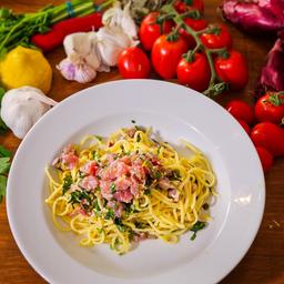 Spaghetti mit Thunfisch und Zitrone auf einem Teller angerichtet. 