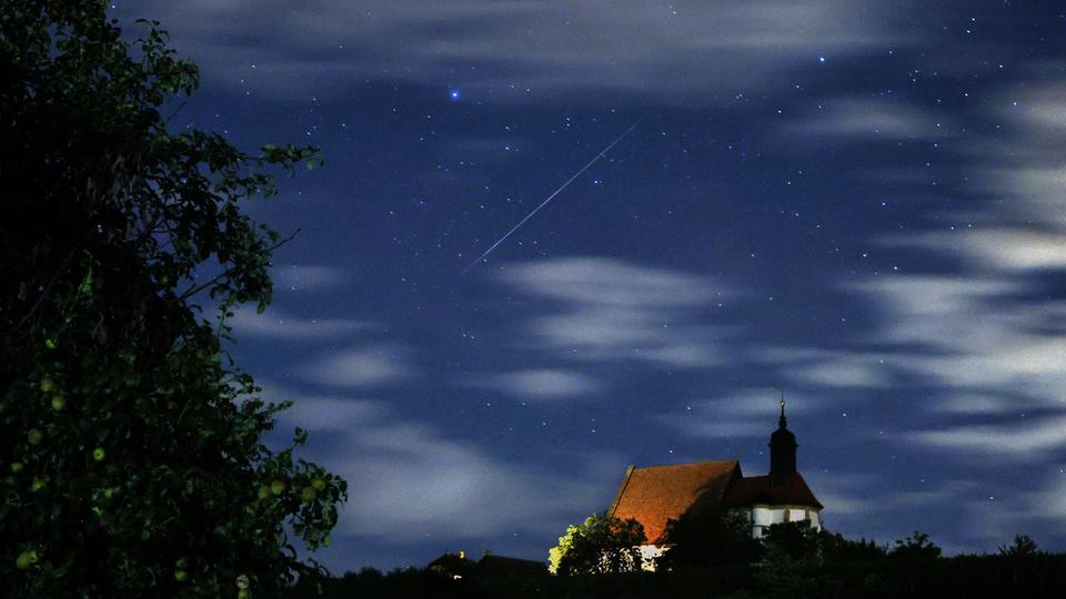 Eine Sternschnuppe verglüht am Himmel